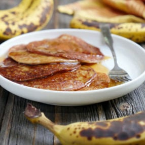 These are gluten-free cardamom spiced banana pancakes - also known as "Banana Malpua" - an Indian dessert. They're light and soft in the middle with crispy edges. Recipe by Ashley of MyHeartBeets.com